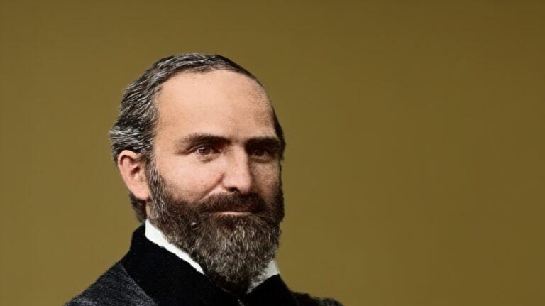 G.D. Watson, a man with a beard and receding hairline, in a suit.