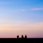 silhouette photography of three person sitting under sky
