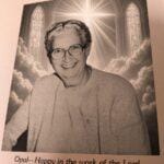 Sister Opal Helphinstine smiling in front of a heavenly scene with stained glass windows.